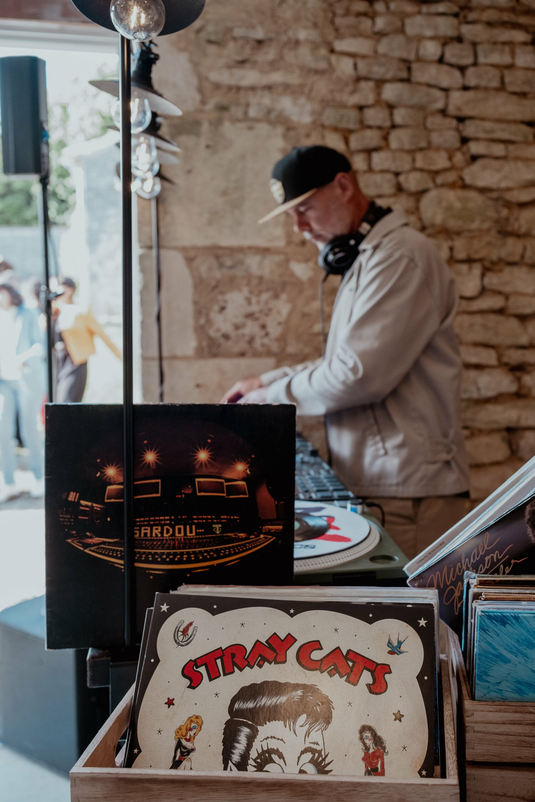 Sylvain aux platines vinyles dans une réception aux murs de pierre